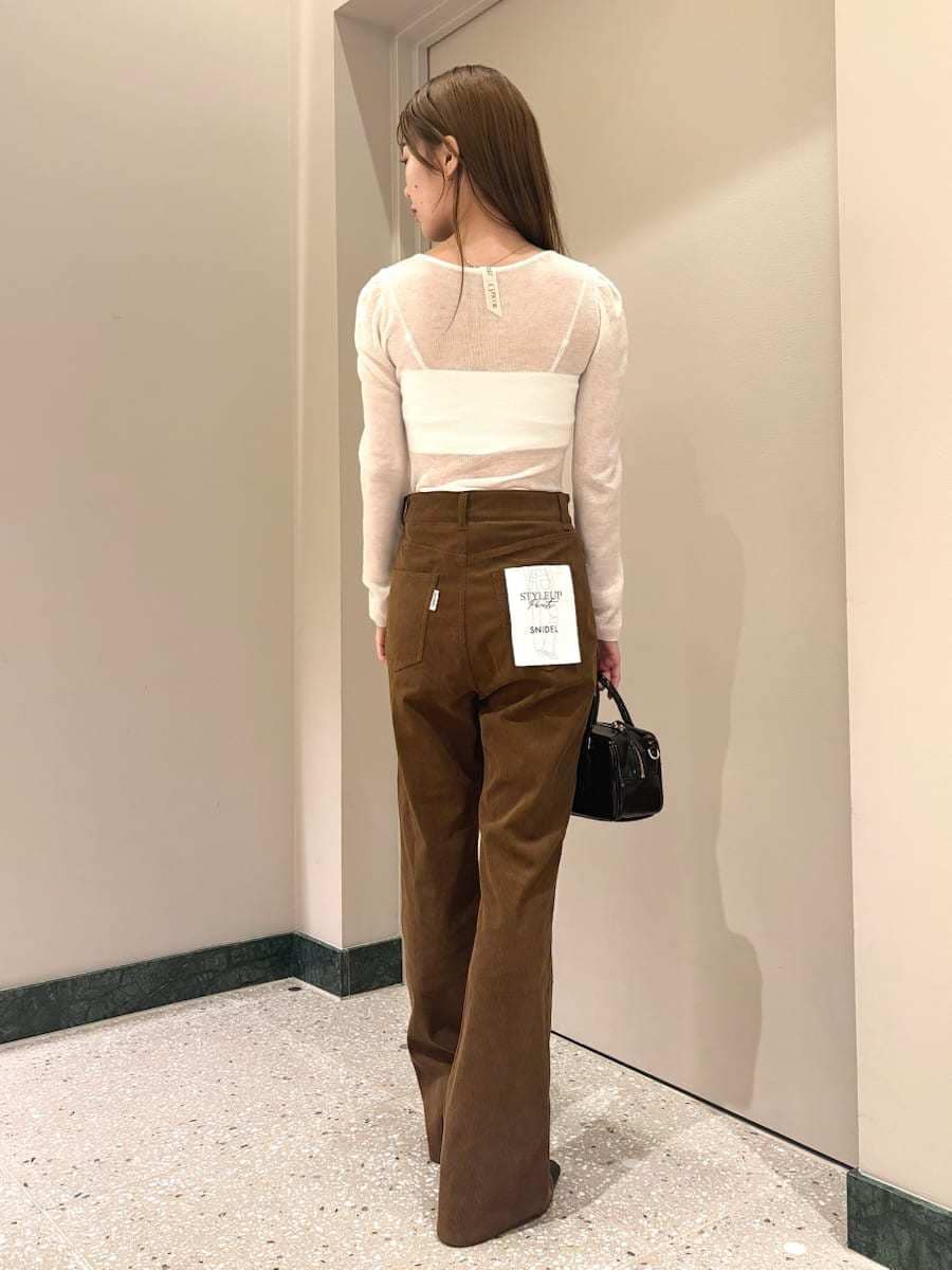 ホワイト系のニット/セーター、ブラウン系のその他パンツ、ブラック系のブーツを着用したレディースの秋コーディネートの5枚目の写真