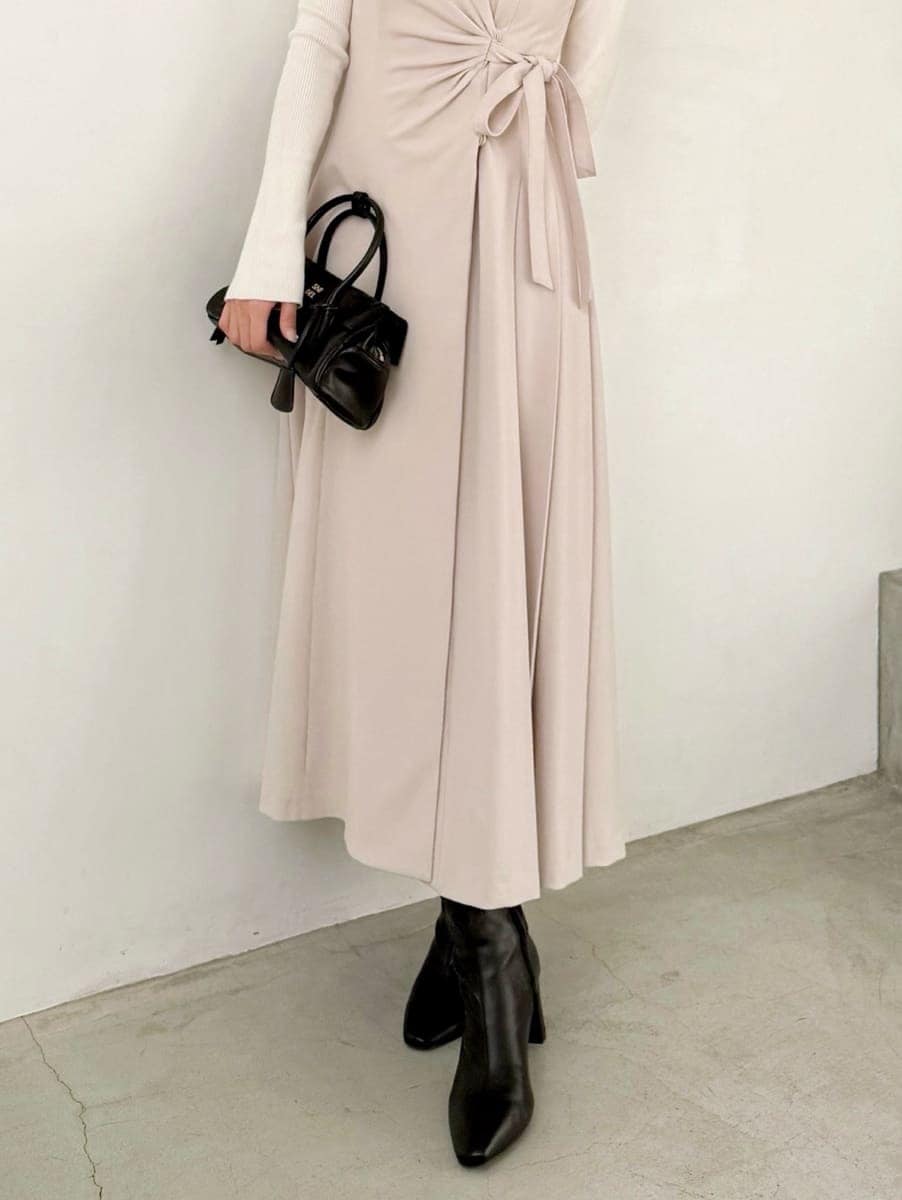 ブラック系のブーツ、ベージュ系のワンピース、ホワイト系のニット/セーターを着用したレディースの秋コーディネートの5枚目の写真