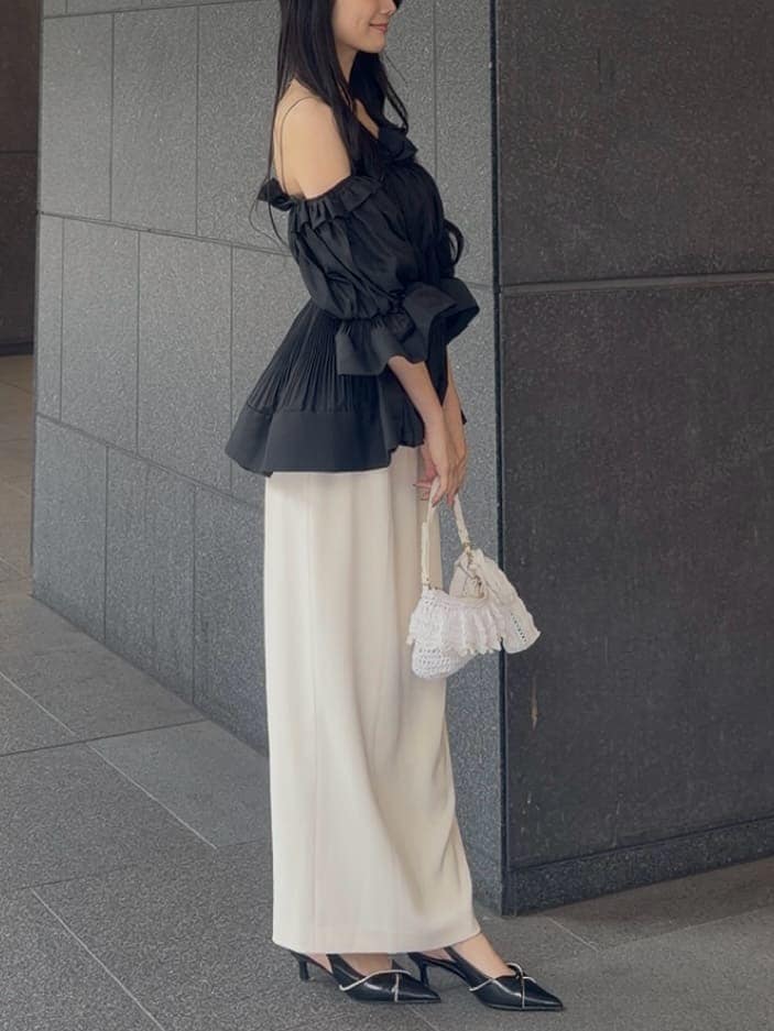 ホワイト系のスカート、ブラック系のその他トップス、ブラック系のパンプスを着用したレディースの春コーディネートの3枚目の写真