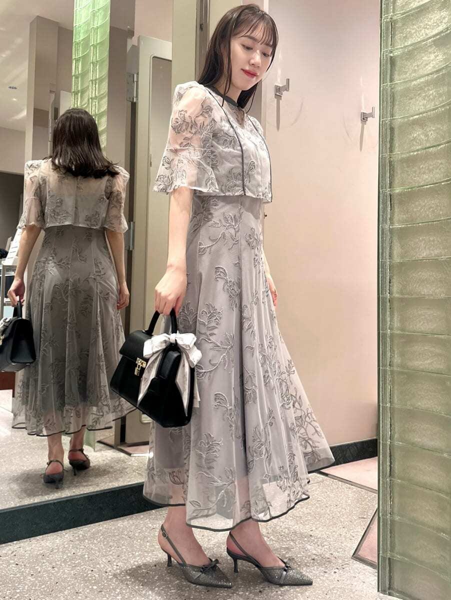 グレー系のワンピース、ブラック系のハンドバッグを着用したレディースの秋コーディネートの4枚目の写真