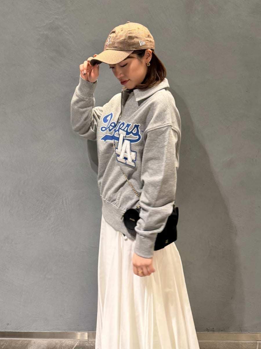 グレー系のスウェット、ブラック系のショルダーバッグ、ホワイト系のスカートを着用したレディースの春コーディネートの7枚目の写真