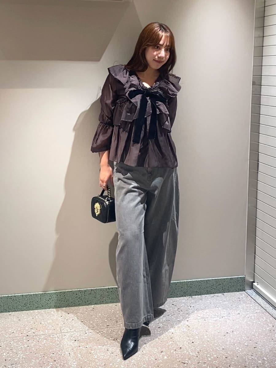 グレー系のデニムパンツ、ブラウン系のシャツ/ブラウス、ブラック系のブーツを着用したレディースの秋コーディネートの2枚目の写真