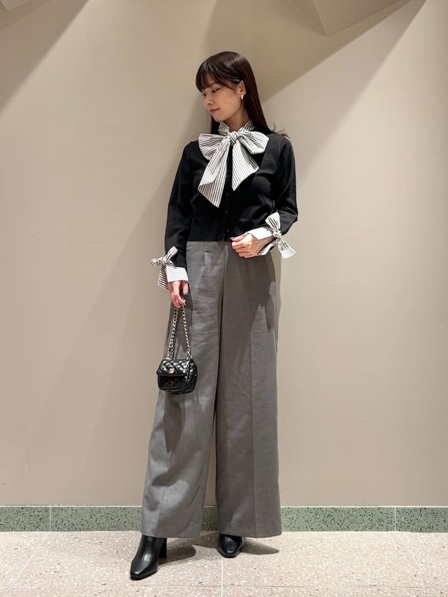 ブラック系のニット/セーター、グレー系のスラックス、ブラック系のショルダーバッグを着用したレディースの秋コーディネートの7枚目の写真