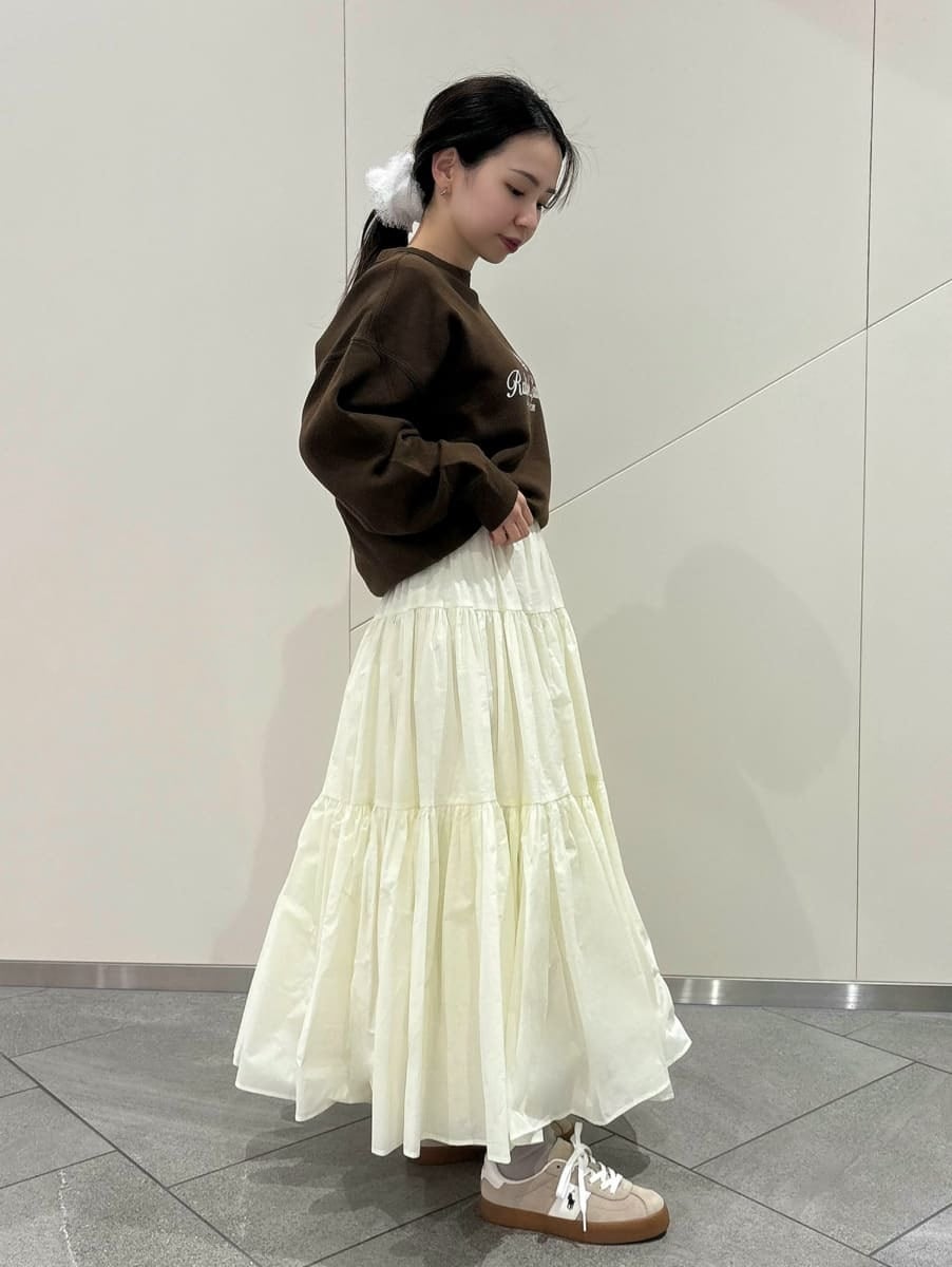 ホワイト系のスカート、ブラウン系のスウェット、イエロー系のショルダーバッグを着用したレディースの春コーディネートの3枚目の写真