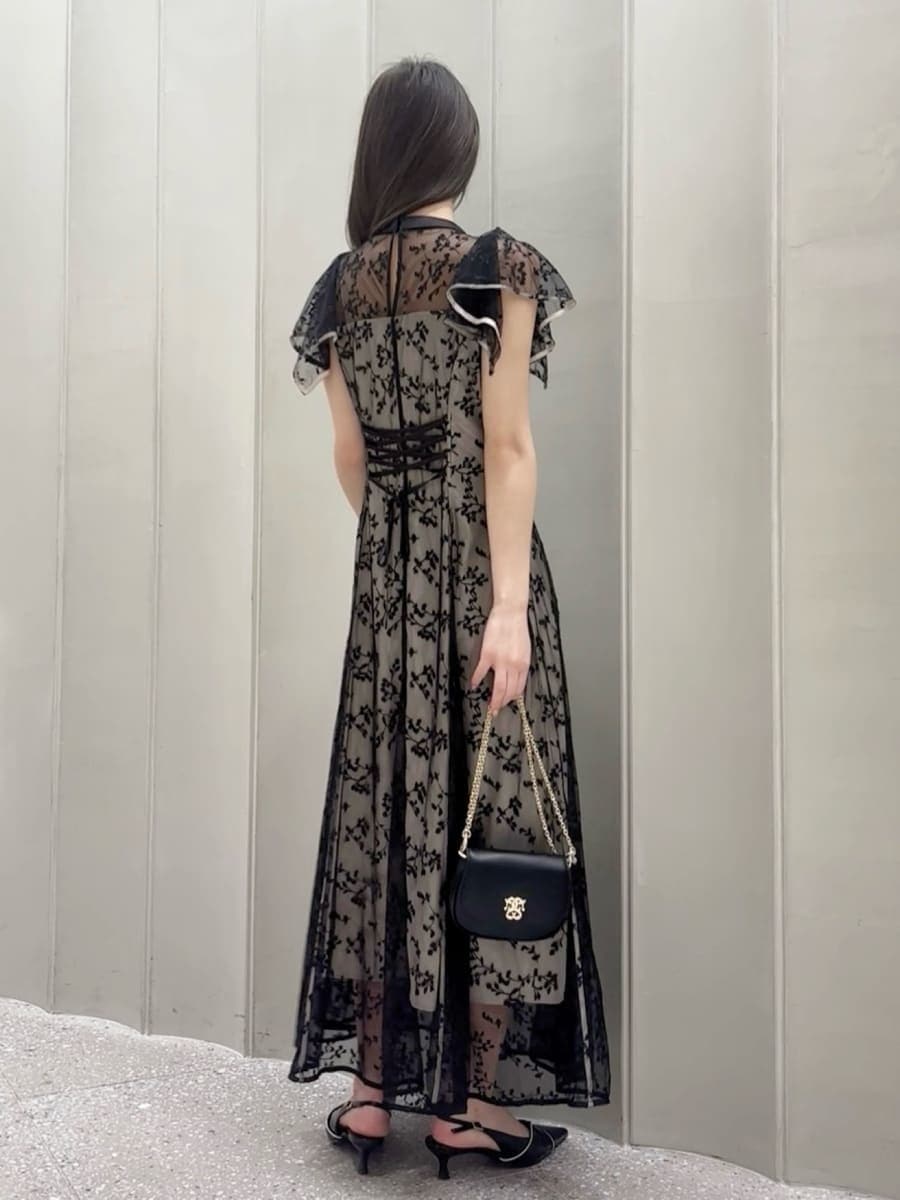 ブラック系のパンプス、ブラック系のショルダーバッグ、ブラック系のドレスを着用したレディースの春コーディネートの3枚目の写真