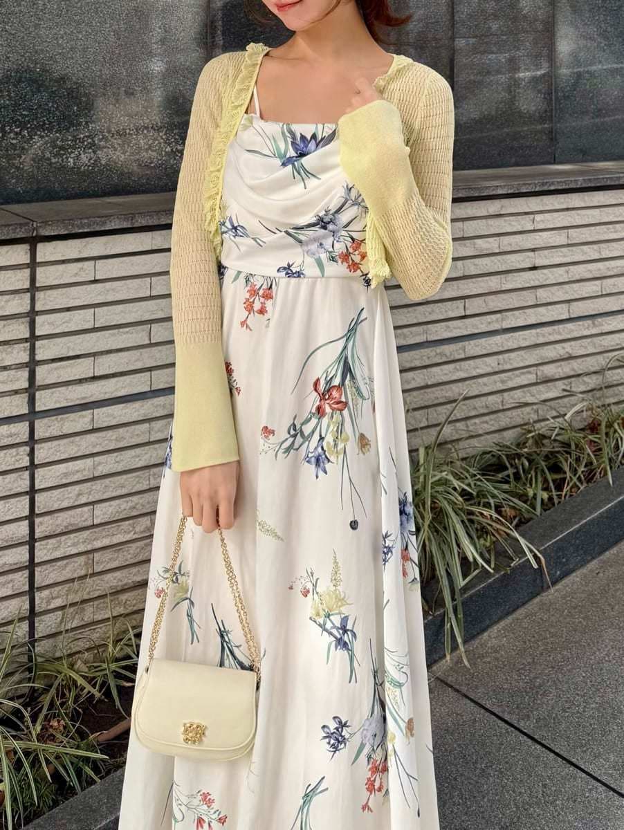 イエロー系のカーディガン/ボレロ、ホワイト系のワンピース、ブラウン系のパンプスを着用したレディースの冬コーディネートの3枚目の写真