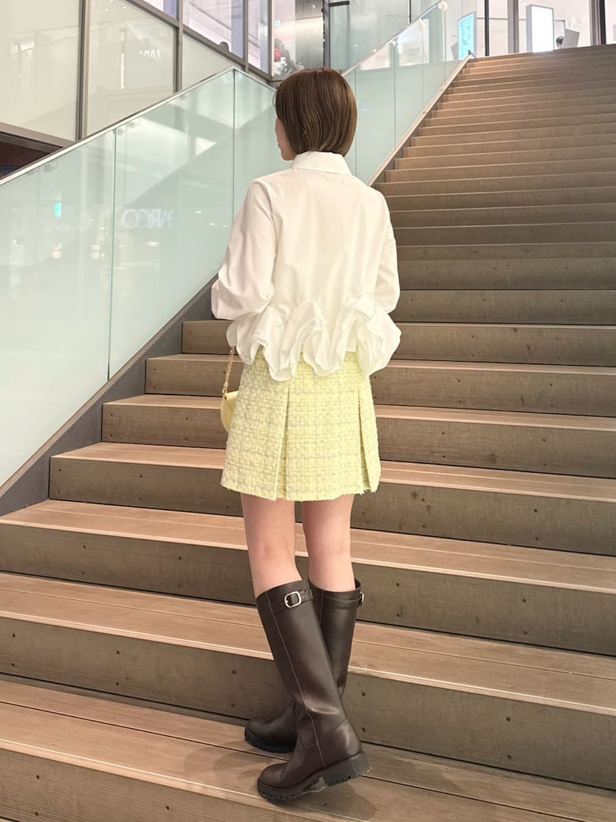 イエロー系のスカート、ホワイト系のシャツ/ブラウス、イエロー系のショルダーバッグを着用したレディースの冬コーディネートの4枚目の写真