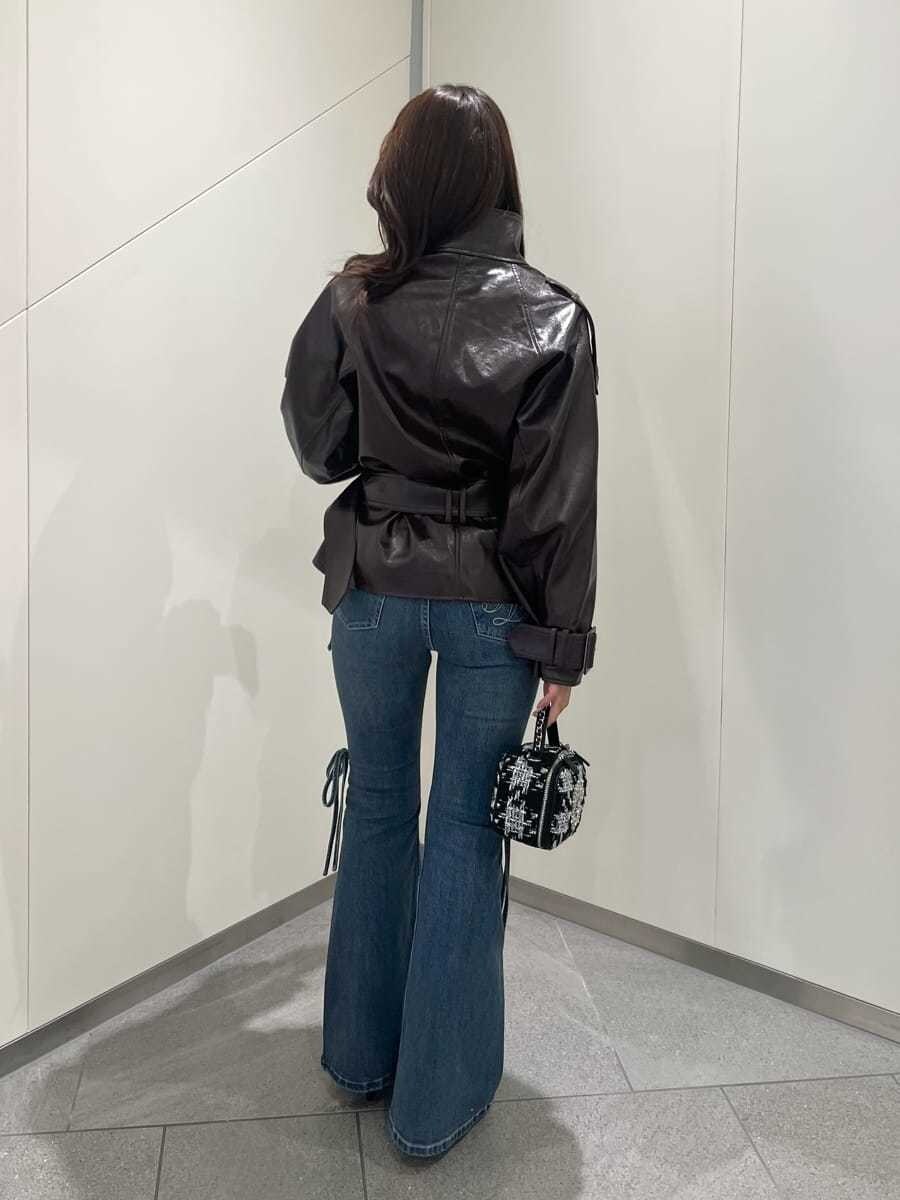 ブラウン系のブルゾン、ブルー系のデニムパンツ、ブラウン系のパンプスを着用したレディースの秋コーディネートの3枚目の写真
