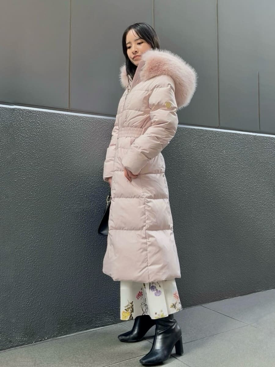 ブラック系のブーツ、ピンク系のダウンジャケット/コート、ブラック系のハンドバッグを着用したレディースの冬コーディネートの5枚目の写真