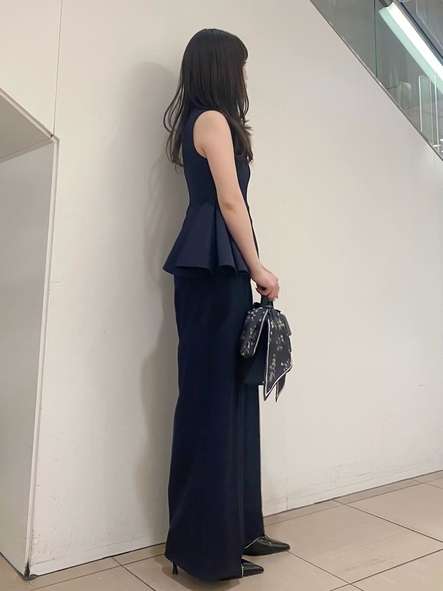 ブルー系のワンピース、ブラック系のパンプス、ブラック系のハンドバッグを着用したレディースの春コーディネートの3枚目の写真