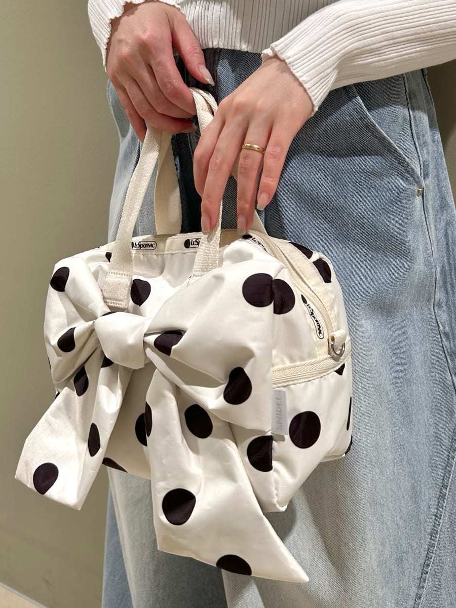 ホワイト系のニット/セーター、ホワイト系のショルダーバッグ、ブルー系のデニムパンツを着用したレディースの夏コーディネートの6枚目の写真