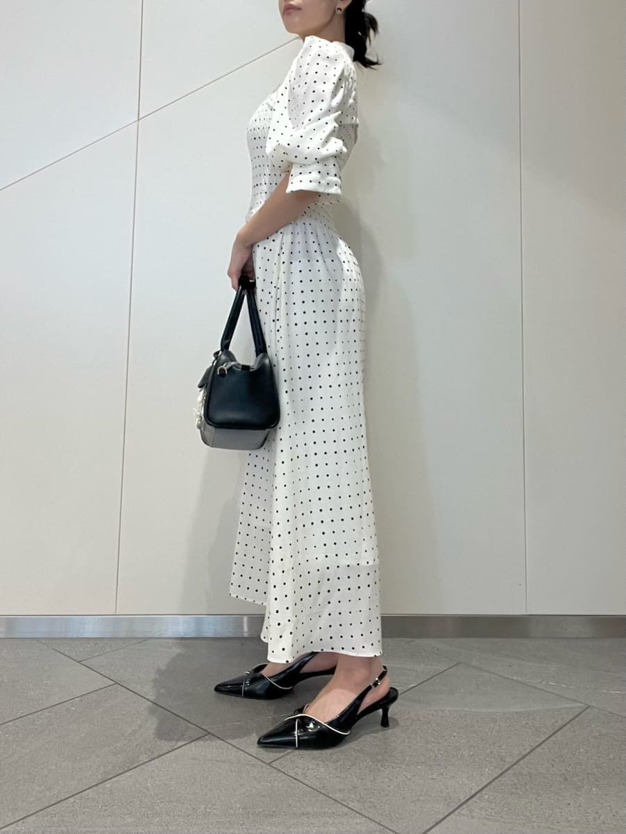 ブラック系のパンプス、ブラック系のボストンバッグ、ホワイト系のワンピースを着用したレディースの春コーディネートの2枚目の写真