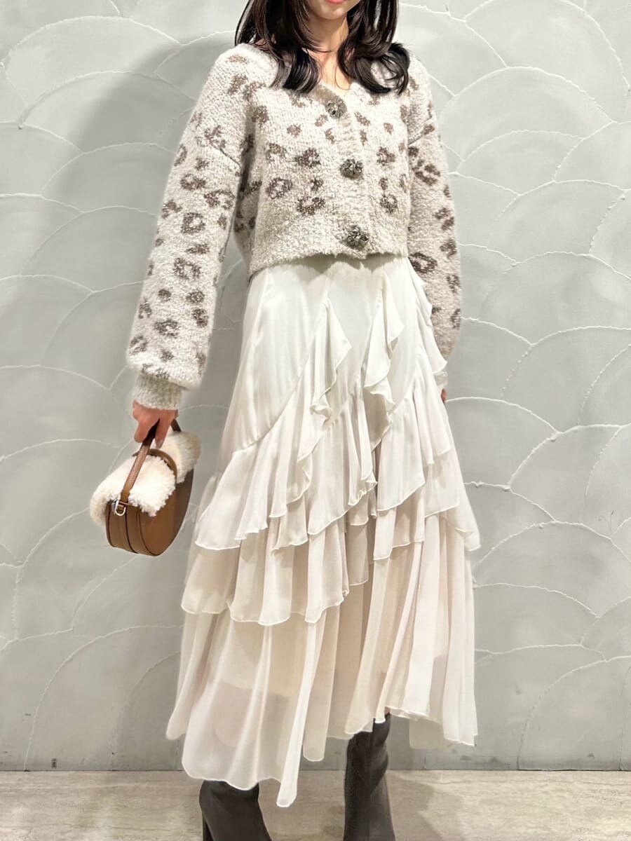 レッド系のブーツ、イエロー系のハンドバッグ、ホワイト系のスカートを着用したレディースの秋コーディネートの2枚目の写真