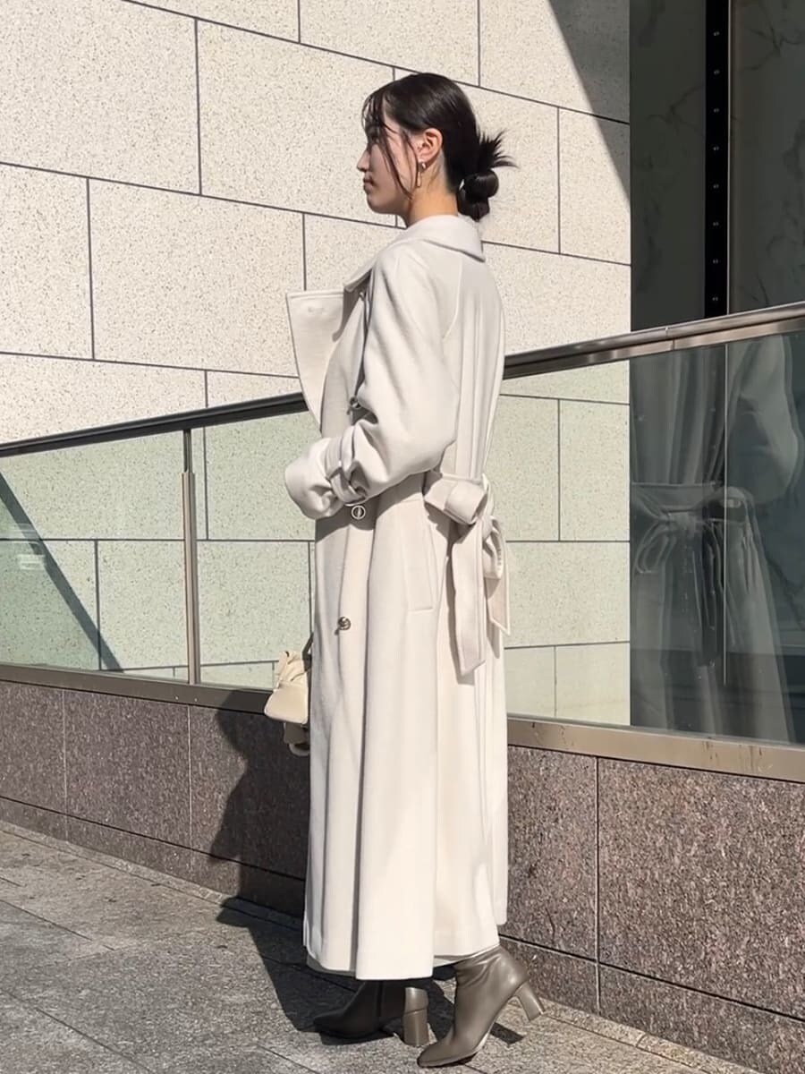 ホワイト系のチェスターコート、ホワイト系のワンピース、ホワイト系のボストンバッグを着用したレディースの秋コーディネートの3枚目の写真