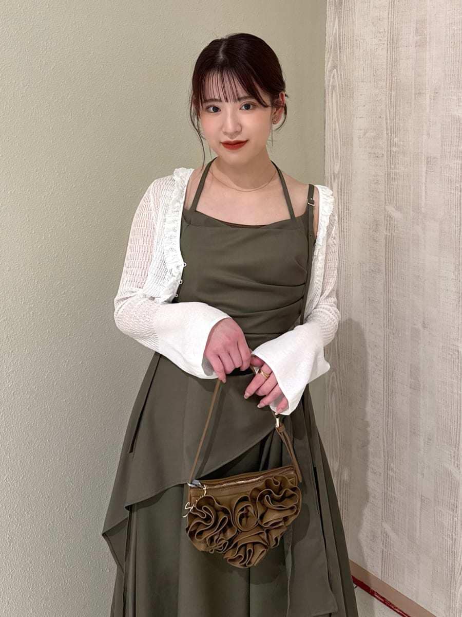 グリーン系のワンピース、ホワイト系のカーディガン/ボレロ、ブラウン系のハンドバッグを着用したレディースの春コーディネートの3枚目の写真