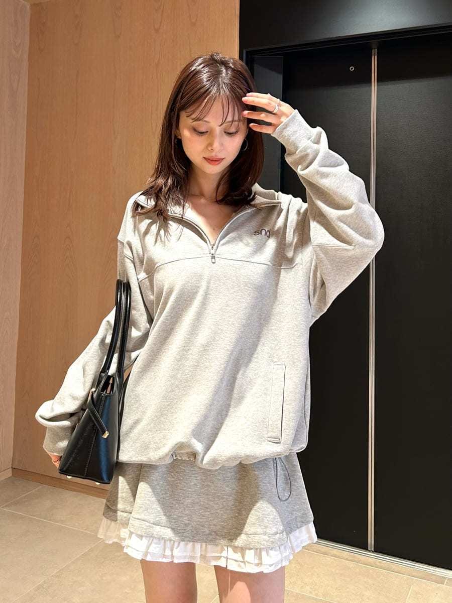 グレー系のワンピース、グレー系のTシャツ/カットソー、ブラック系のブーツを着用したレディースの秋コーディネートの2枚目の写真