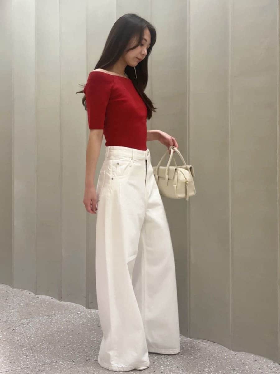ホワイト系のボストンバッグ、ホワイト系のデニムパンツ、レッド系のニット/セーターを着用したレディースの夏コーディネートの3枚目の写真