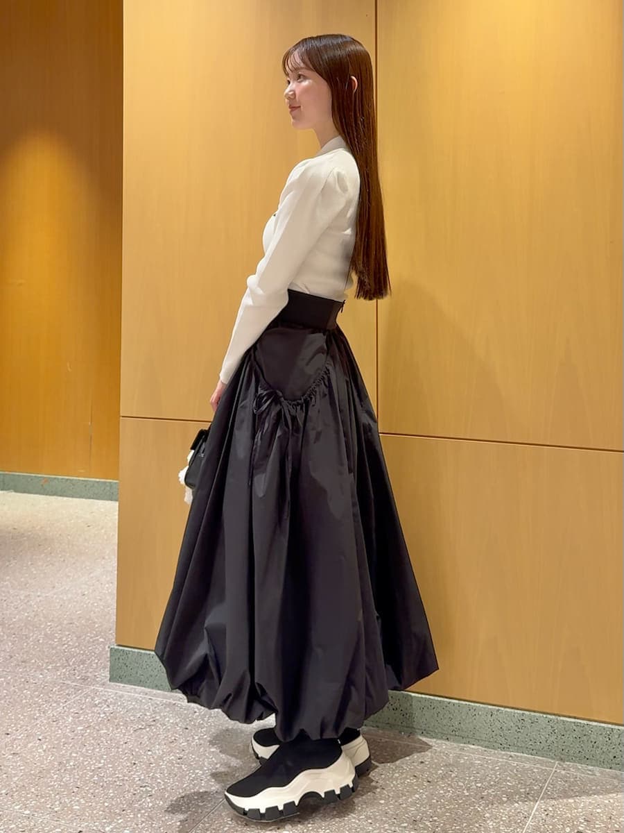 ホワイト系のニット/セーター、ブラック系のスカート、その他のブーツを着用したレディースの秋コーディネートの2枚目の写真