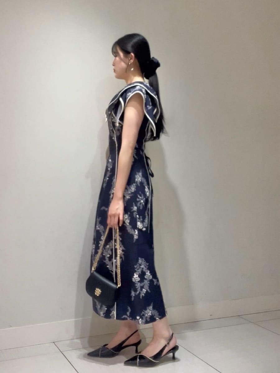 ブルー系のワンピース、ブラック系のパンプス、ブラック系のショルダーバッグを着用したレディースの春コーディネートの2枚目の写真