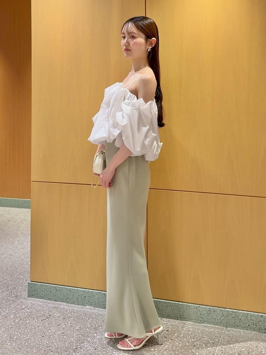 グリーン系のスカート、ホワイト系のシャツ/ブラウス、ホワイト系のショルダーバッグを着用したレディースの春コーディネートの2枚目の写真