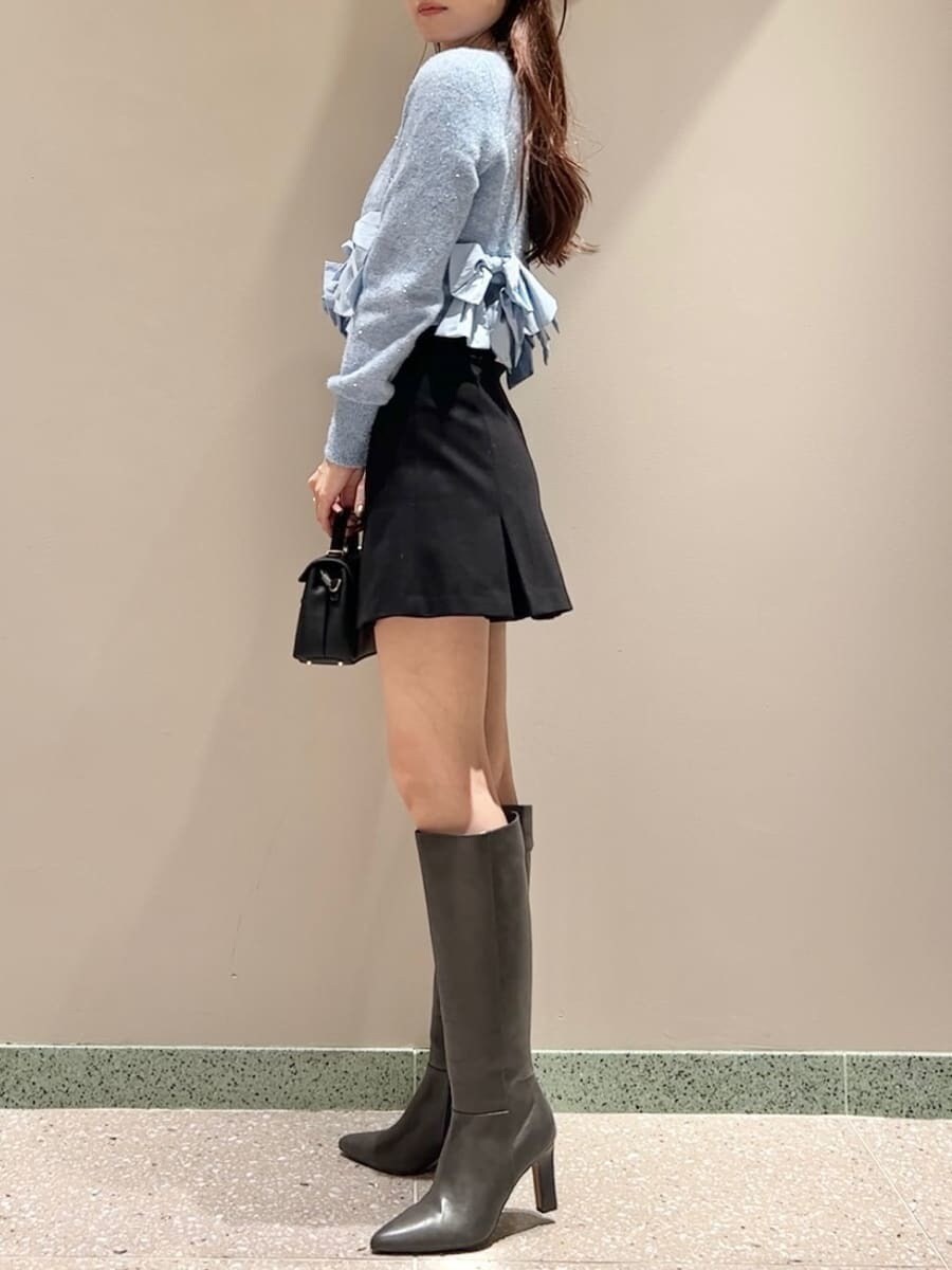 ブルー系のニット/セーター、ブラック系のスカート、ブラック系のショルダーバッグを着用したレディースの秋コーディネートの3枚目の写真