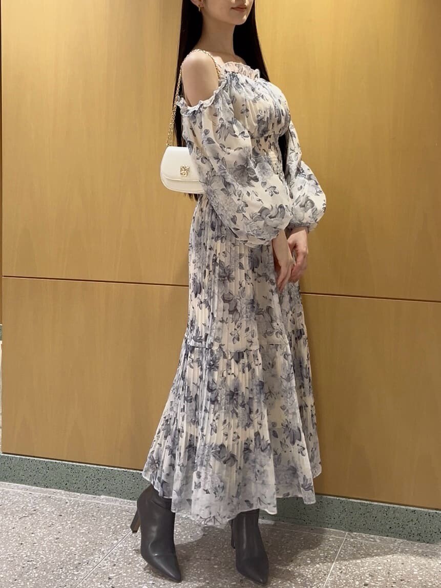 グレー系のブーツ、イエロー系のワンピース、ホワイト系のショルダーバッグを着用したレディースの冬コーディネートの3枚目の写真