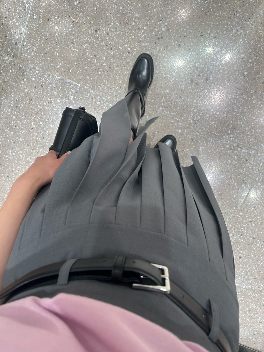 ピンク系のニット/セーター、グレー系のスカート、ブラック系のハンドバッグを着用したレディースの夏コーディネートの5枚目の写真