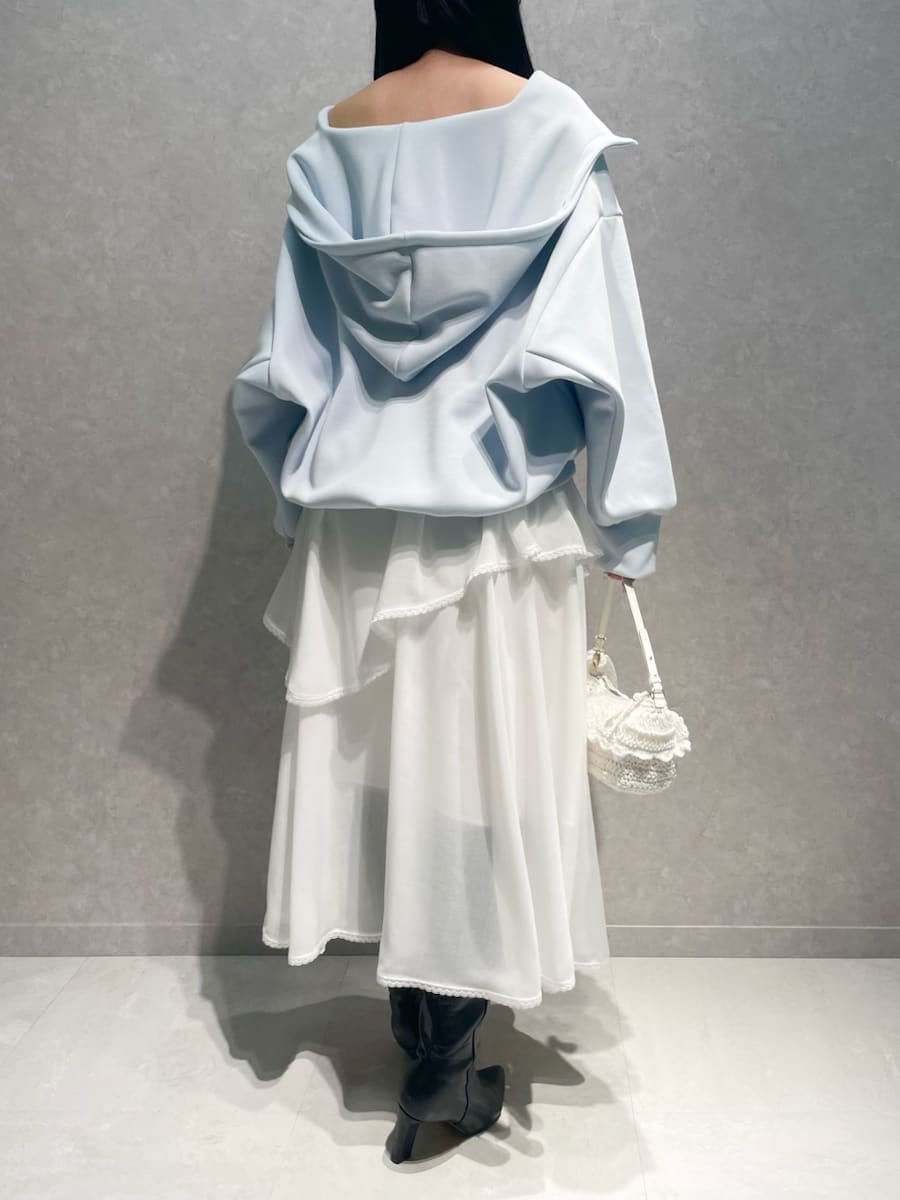 ブラック系のブーツ、ホワイト系のスカート、ブルー系のパーカーを着用したレディースの冬コーディネートの3枚目の写真