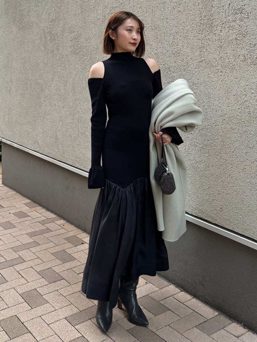 グレー系のブーツ、グリーン系のチェスターコート、ブラック系のワンピースを着用したレディースの秋コーディネートの9枚目の写真