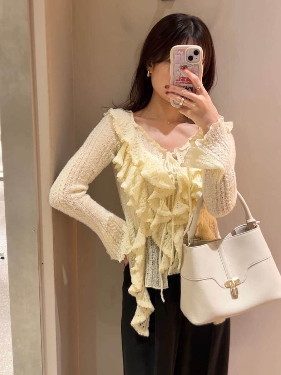 イエロー系のニット/セーター、ホワイト系のハンドバッグを着用したレディースの冬コーディネートの5枚目の写真