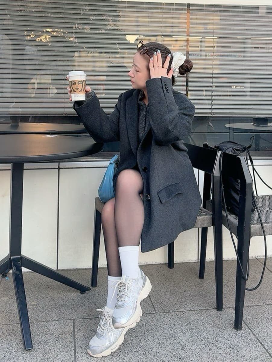 グレー系のニット/セーター、グレー系のテーラードジャケットを着用したレディースの冬コーディネートの2枚目の写真