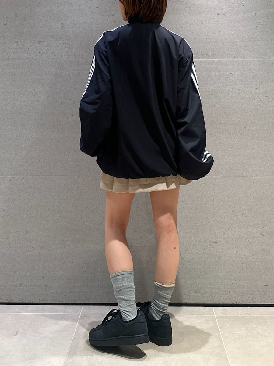 ベージュ系のスカート、ブラック系のブルゾン、ブラック系のスニーカーを着用したレディースの冬コーディネートの6枚目の写真