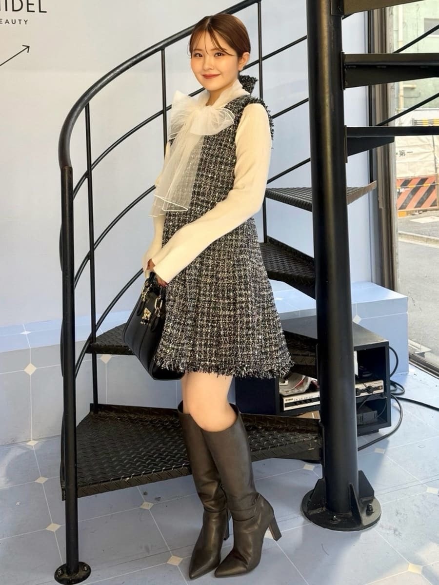 グレー系のブーツ、ブルー系のワンピース、ブラック系のハンドバッグを着用したレディースの冬コーディネートの3枚目の写真