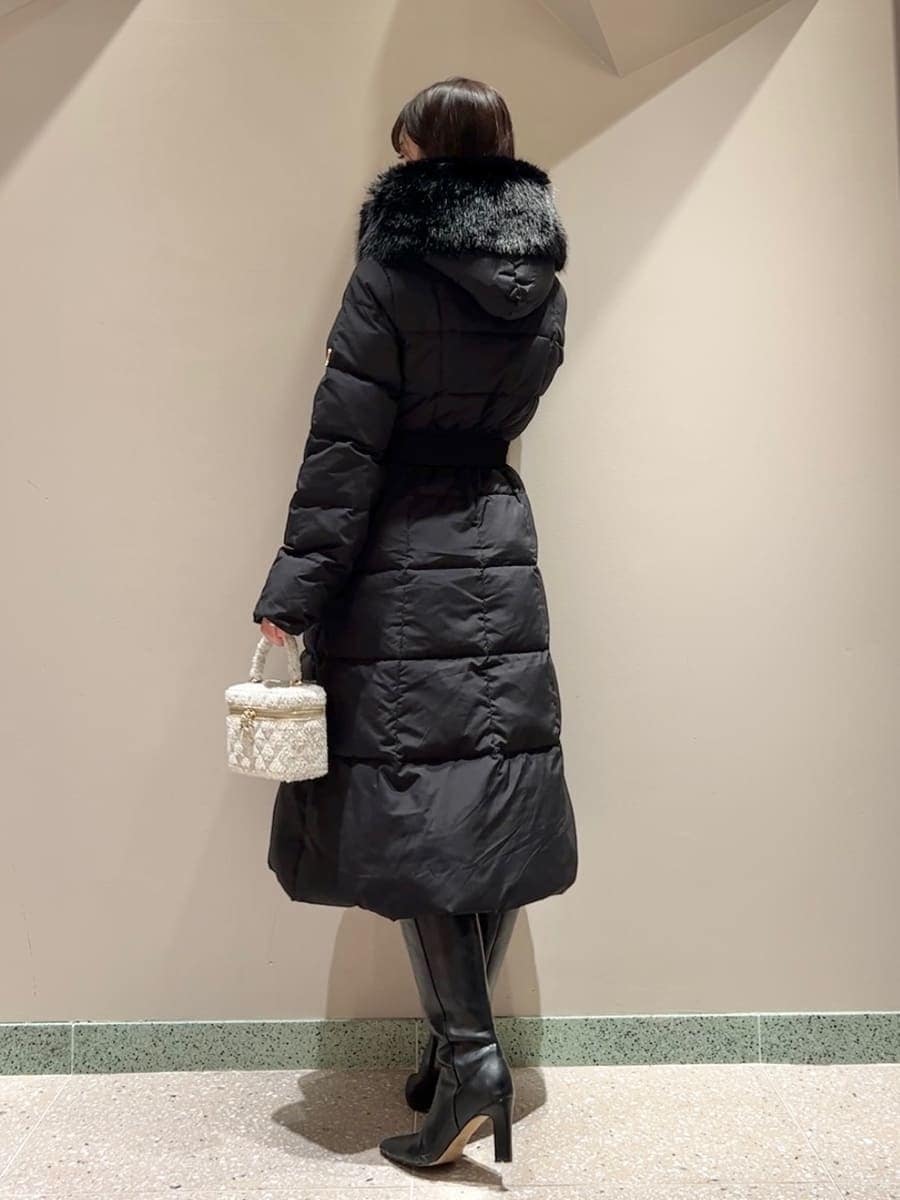 ホワイト系のニット/セーター、ブラック系のブーツ、ブラック系のダウンジャケット/コートを着用したレディースの冬コーディネートの3枚目の写真
