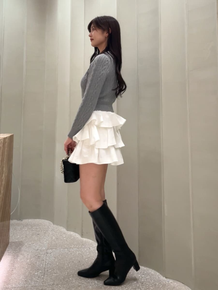ホワイト系のその他パンツ、グレー系のニット/セーター、ブラック系のブーツを着用したレディースの秋コーディネートの5枚目の写真