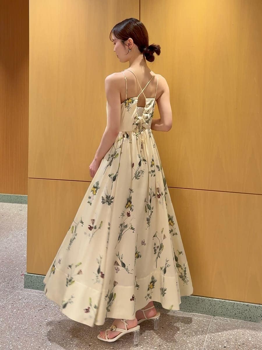 イエロー系のワンピース、ホワイト系のカーディガン/ボレロ、ベージュ系のショルダーバッグを着用したレディースの春コーディネートの4枚目の写真