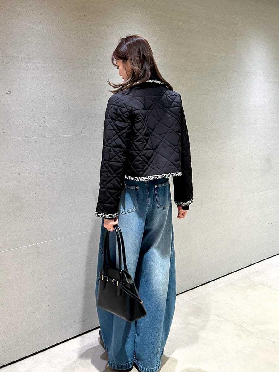 ブルー系のデニムパンツ、ブラック系のテーラードジャケット、ブラック系のニット/セーターを着用したレディースの秋コーディネートの4枚目の写真