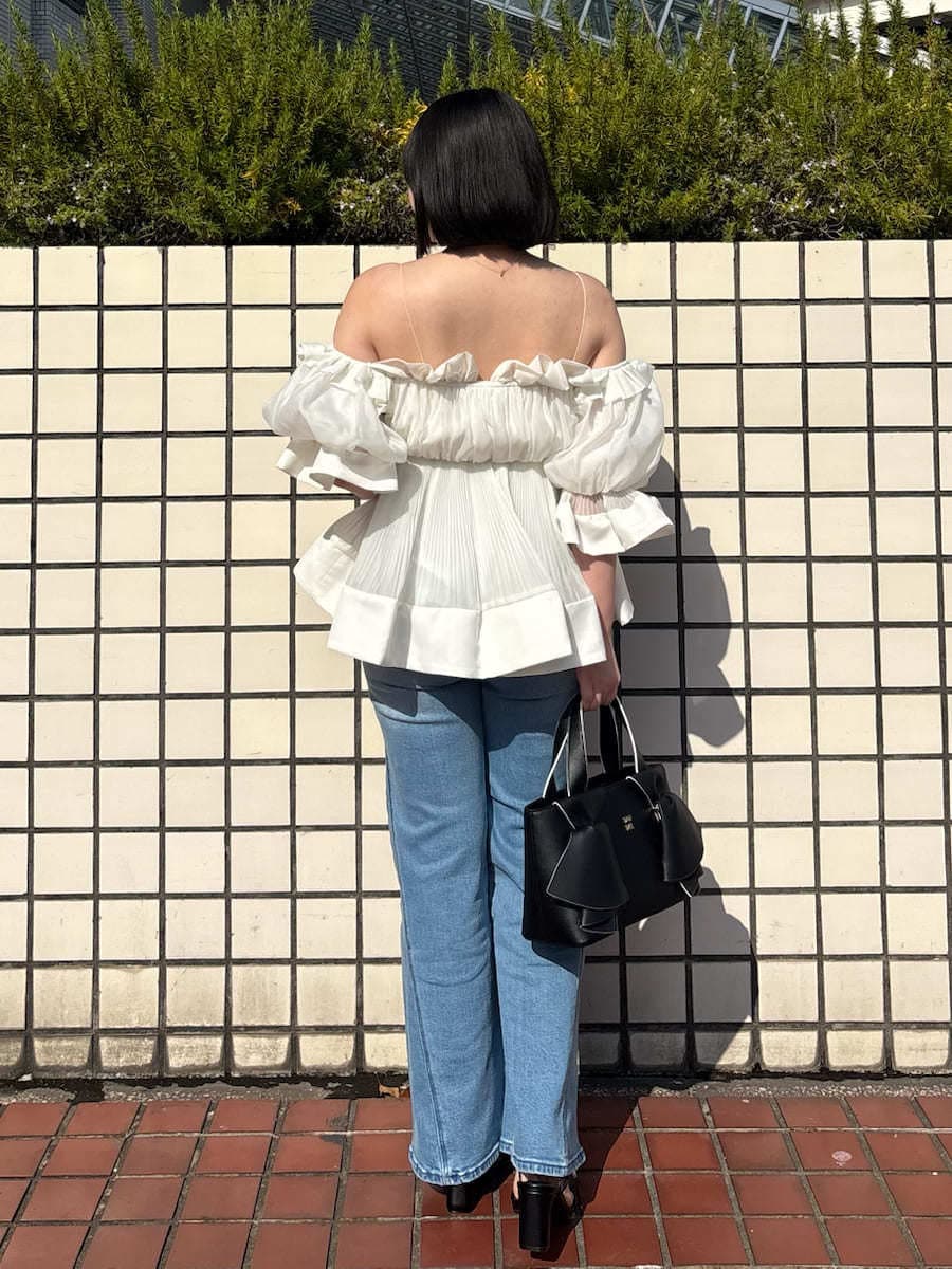 ブルー系のデニムパンツ、ホワイト系のその他トップス、ブラック系のハンドバッグを着用したレディースの春コーディネートの5枚目の写真