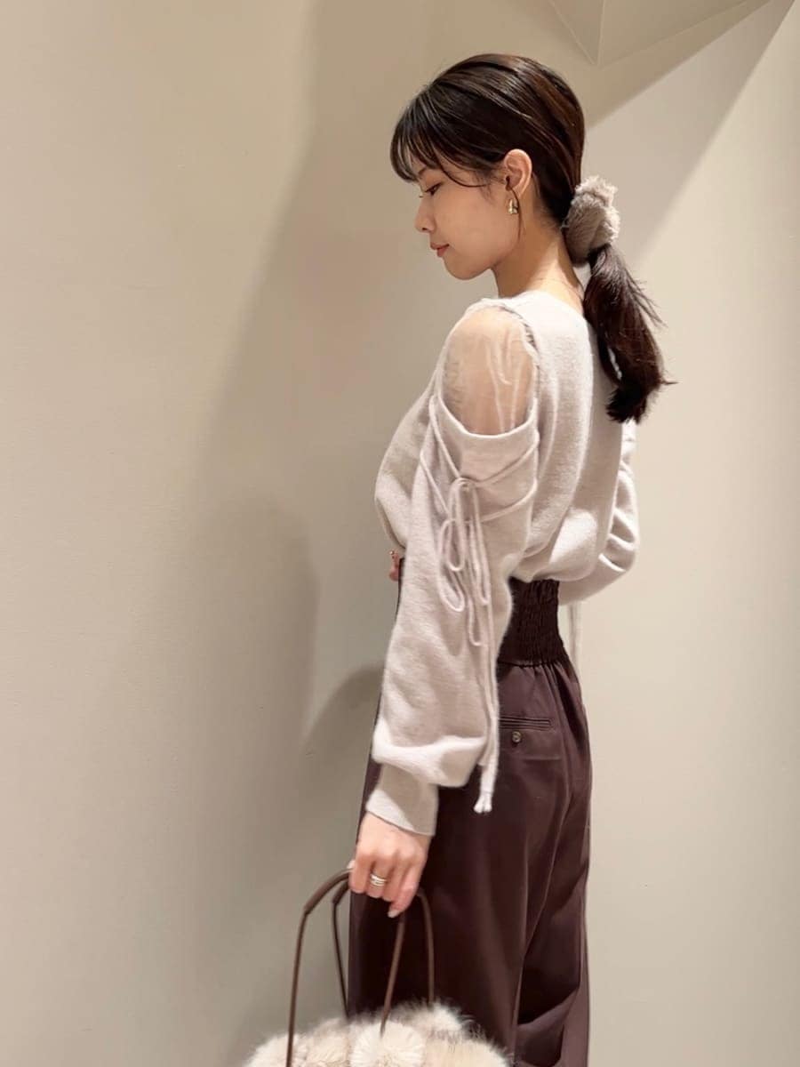 ブラウン系のスラックス、ピンク系のニット/セーター、ブラウン系のハンドバッグを着用したレディースの冬コーディネートの6枚目の写真