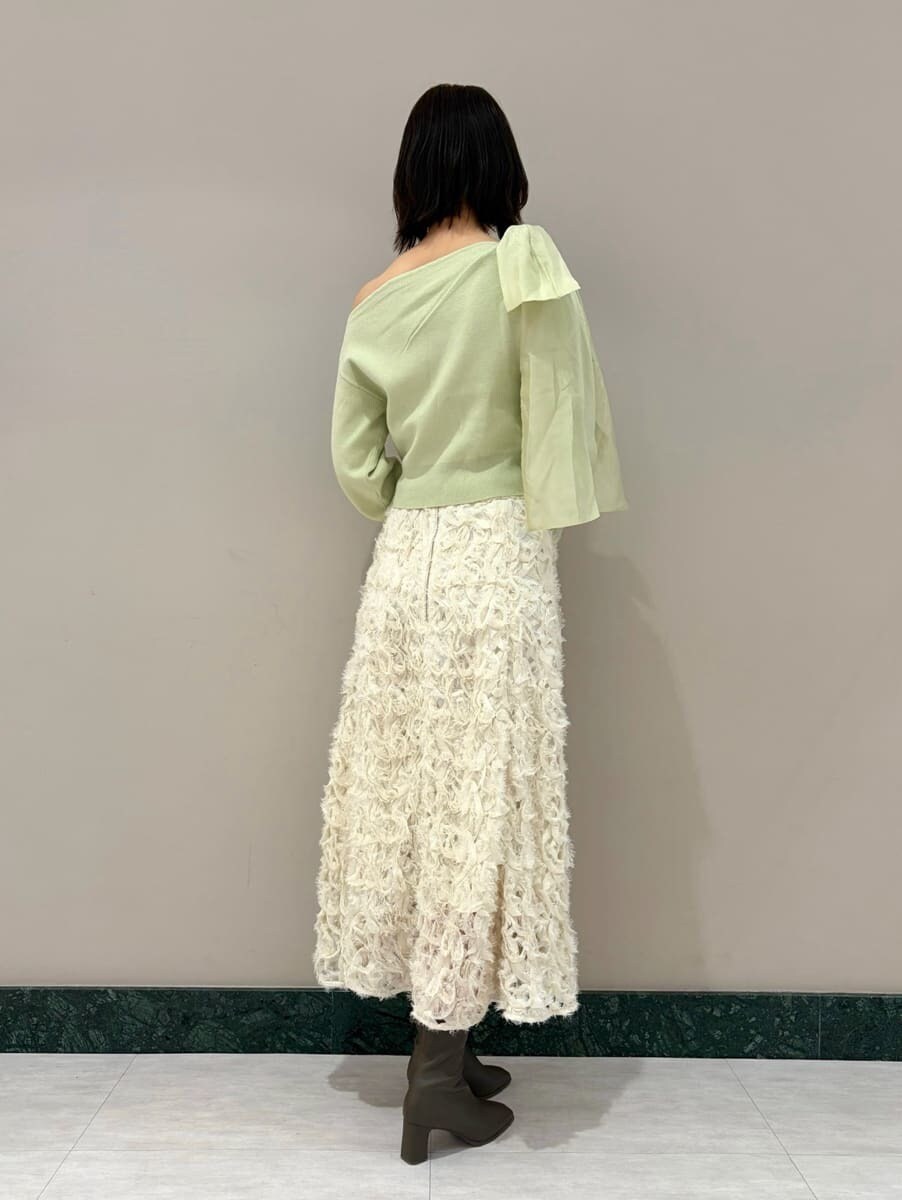 ホワイト系のスカート、グリーン系のニット/セーターを着用したレディースの冬コーディネートの2枚目の写真