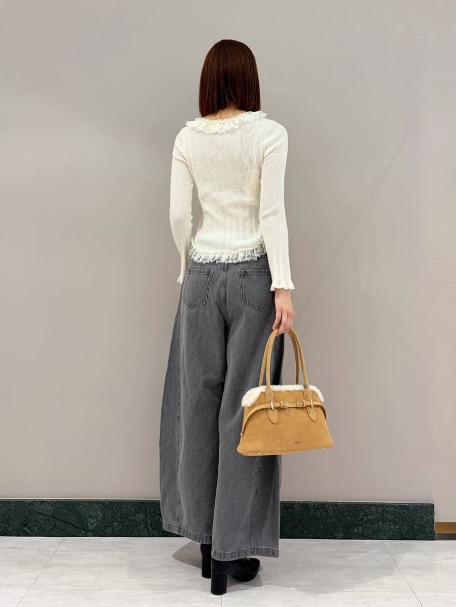 グレー系のデニムパンツ、ホワイト系のニット/セーター、ブラック系のブーツを着用したレディースの夏コーディネートの2枚目の写真