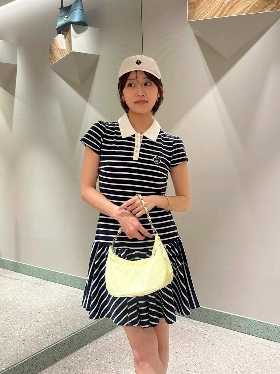 ブルー系のワンピース、イエロー系のショルダーバッグ、ホワイト系のキャップを着用したレディースの夏コーディネートの3枚目の写真