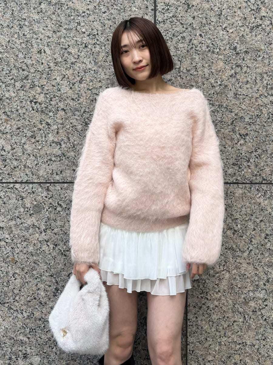 ブラック系のブーツ、ピンク系のニット/セーター、ホワイト系のその他パンツを着用したレディースの冬コーディネートの4枚目の写真