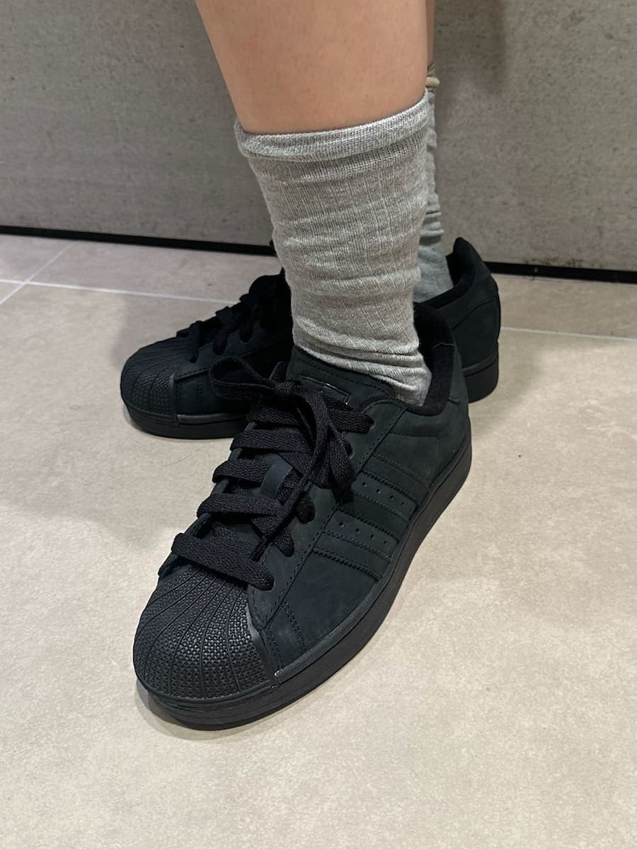 ベージュ系のスカート、ブラック系のブルゾン、ブラック系のスニーカーを着用したレディースの冬コーディネートの8枚目の写真