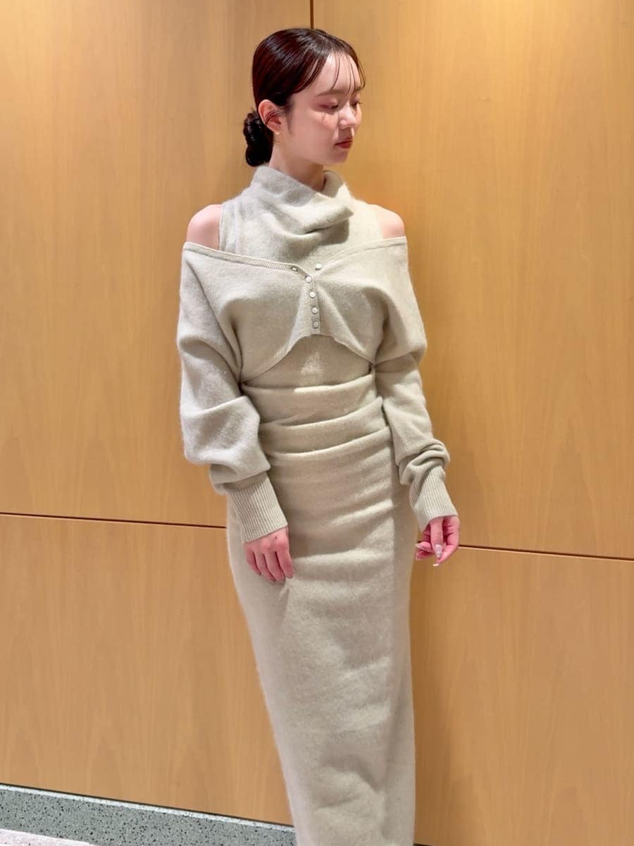 ブラック系のブーツ、グリーン系のワンピース、ブラック系のハンドバッグを着用したレディースの冬コーディネートの5枚目の写真