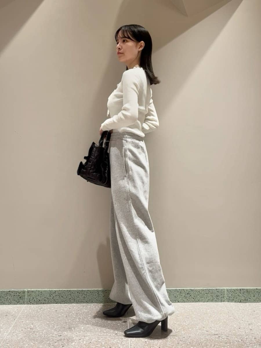 ホワイト系のニット/セーター、グレー系のその他パンツ、ブラック系のブーツを着用したレディースの秋コーディネートの2枚目の写真