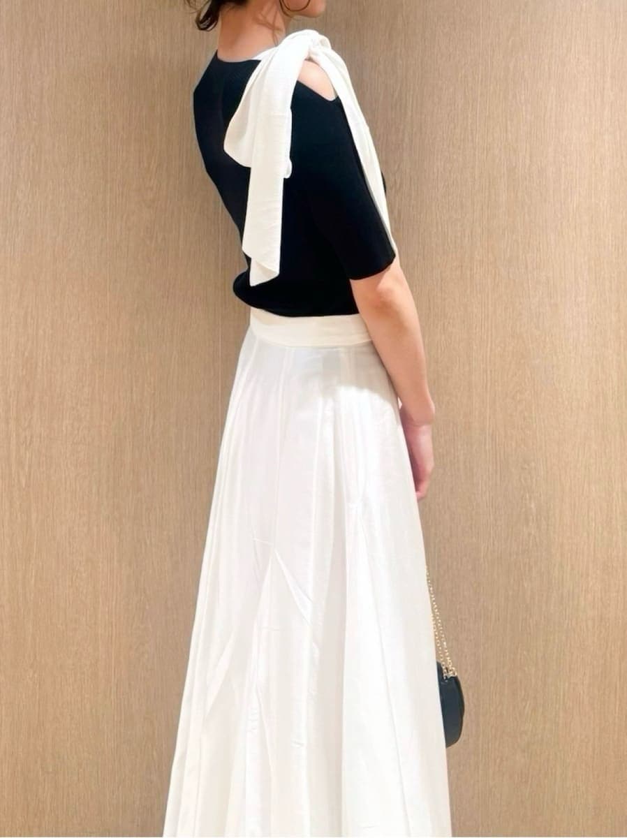 ブラック系のパンプス、ブラック系のショルダーバッグ、ブラック系のニット/セーターを着用したレディースの春コーディネートの4枚目の写真