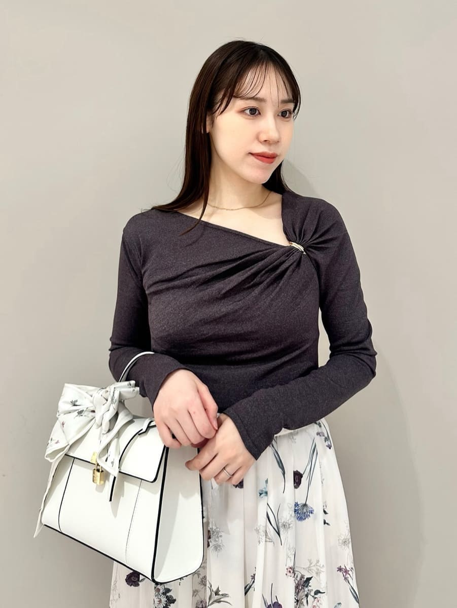 ホワイト系のスカート、グレー系のニット/セーター、ブラック系のパンプスを着用したレディースの冬コーディネートの2枚目の写真