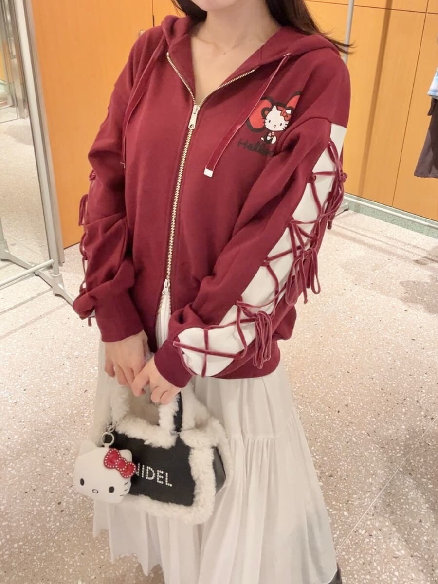 レッド系のパーカー、ホワイト系のスカート、ブラック系のハンドバッグを着用したレディースの秋コーディネートの6枚目の写真