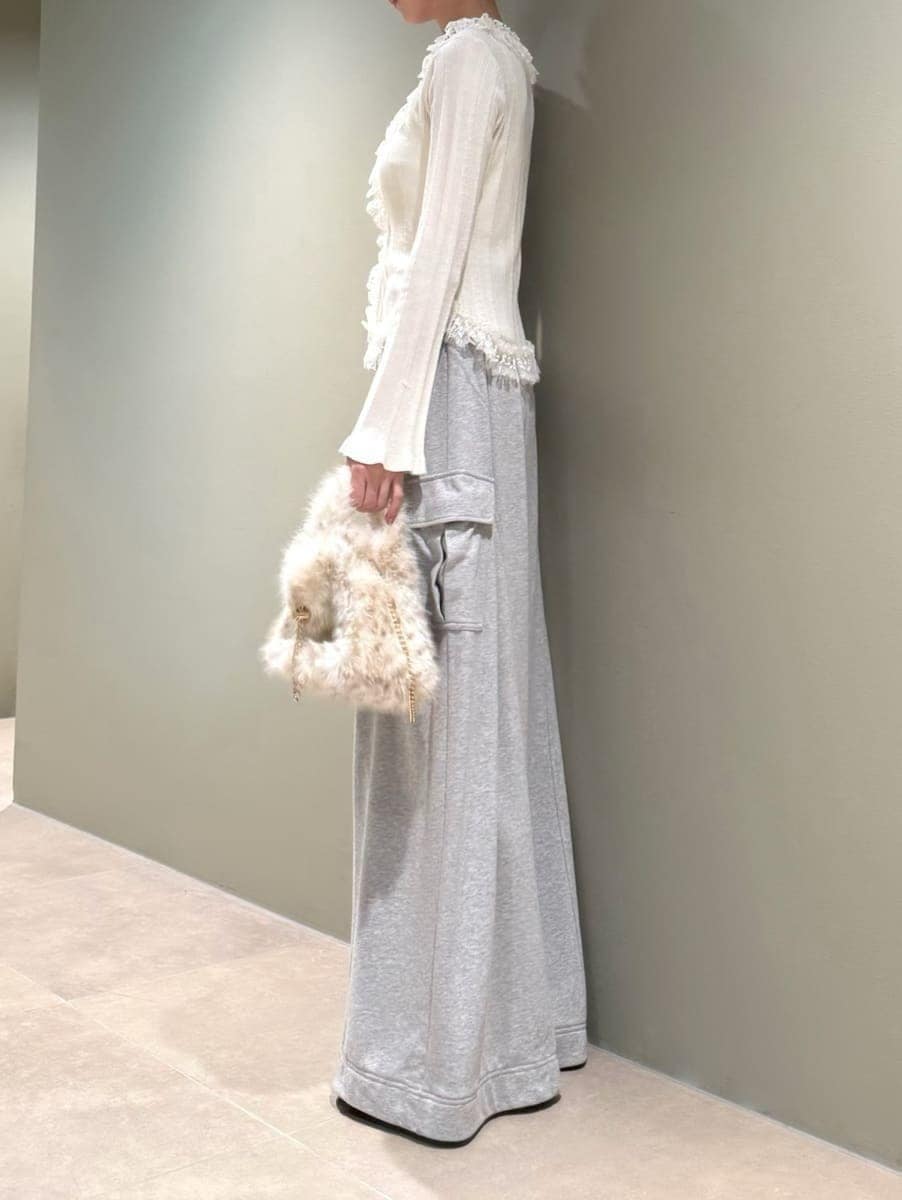グレー系のその他パンツ、ホワイト系のニット/セーター、ブラック系のサンダルを着用したレディースの夏コーディネートの2枚目の写真